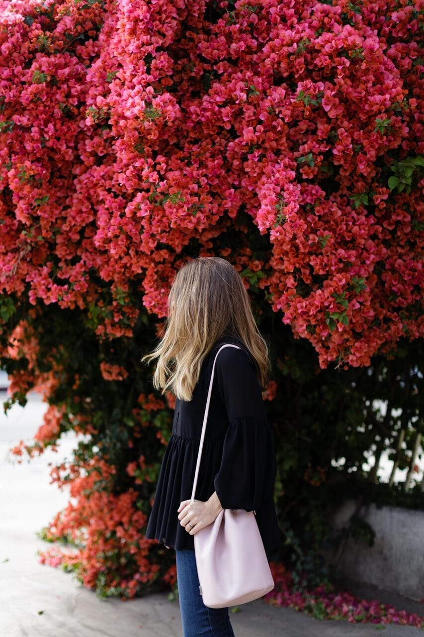 Woman Standing in Front of Flower Bush