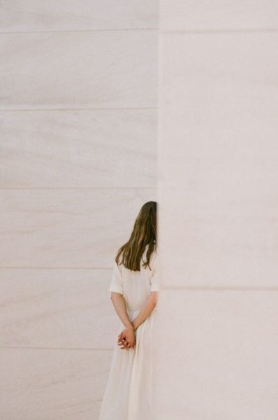 Woman Standing Behind a Wall