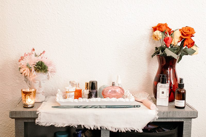 perfume and flowers on a shelf studio apartment wit & delight