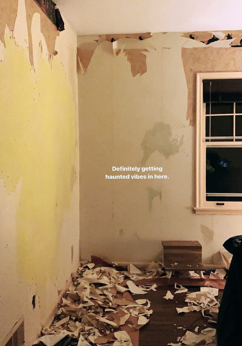 Stripping wallpaper in a small room with a window.