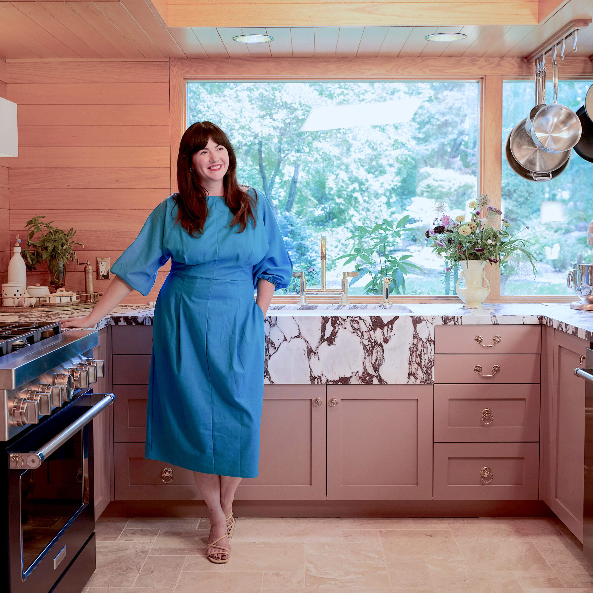 Woman standing in a colorful kitchen smiling