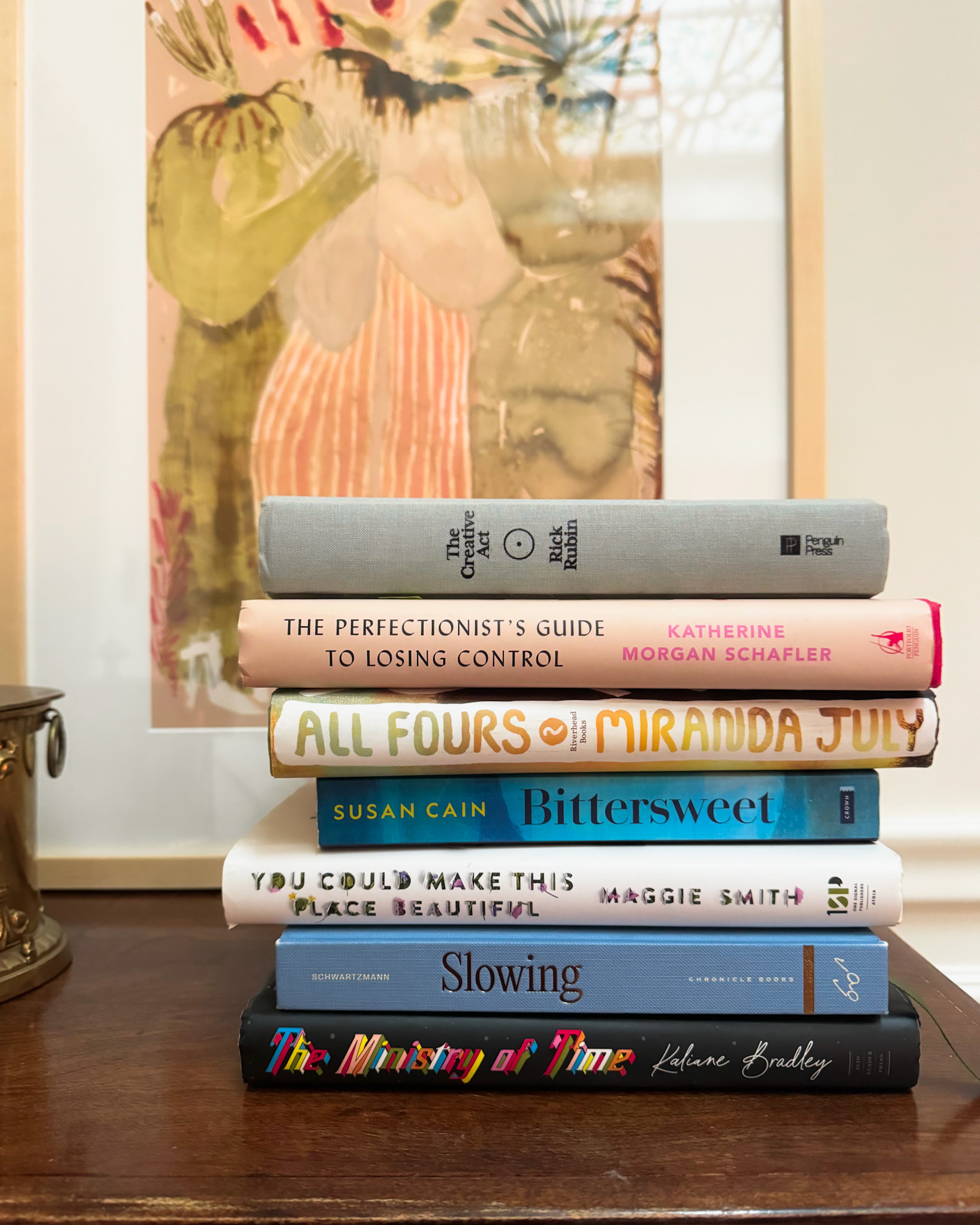 A stack of the best books 2024 sits on top of a wooden dresser
